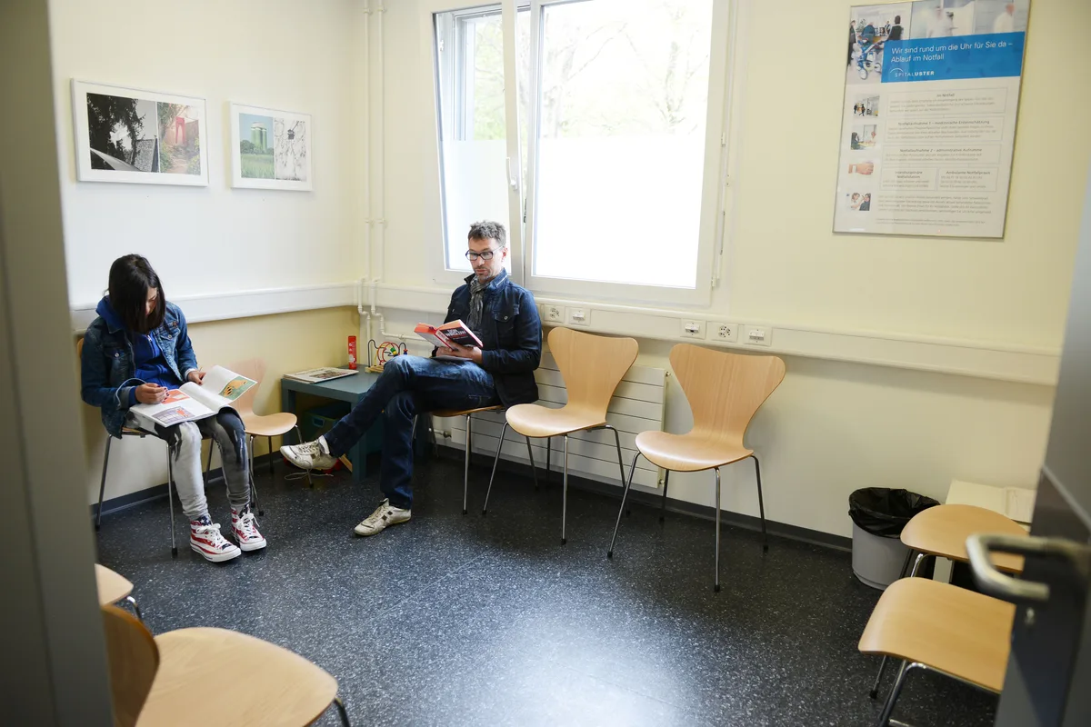 Zwei Leute sitzen auf Stühlen. 